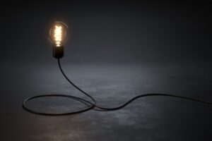 A lit lightbulb on a dark background.